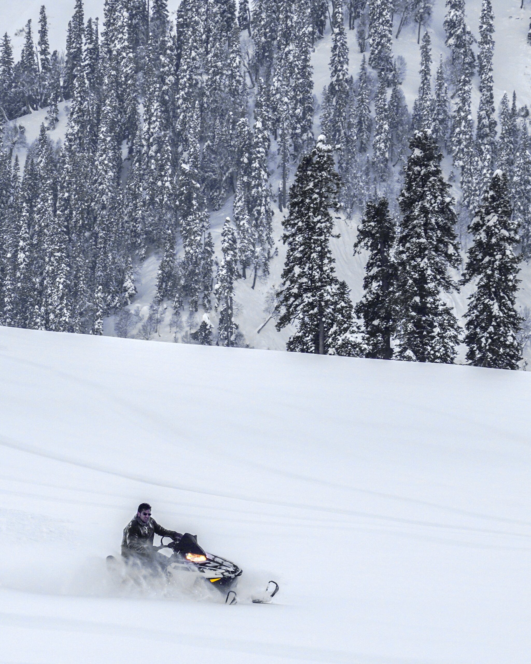 A Man Riding Snowmobile on Snow Covered Mountain Slope